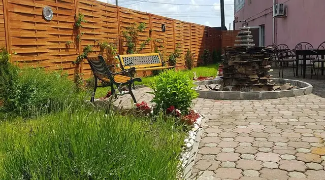 Curtea pavată cu gazon și fântână