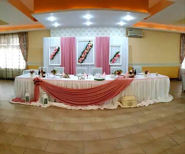 Prezidiul decorat cu draperii roz și flori